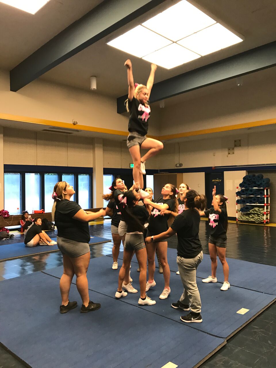 The Cheer Team practices a stunt.
