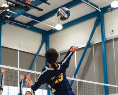 Kylie Dang approaches for a spike against two blockers.