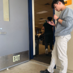 Nathan Do checks his phone outside classroom L-46 during lunch.